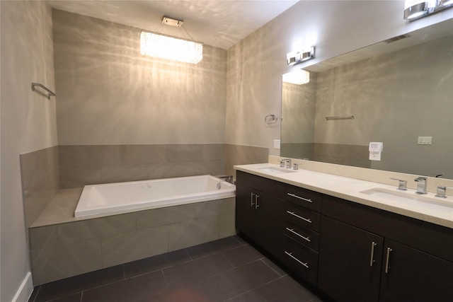 bathroom featuring tile patterned flooring, vanity, and tiled bath