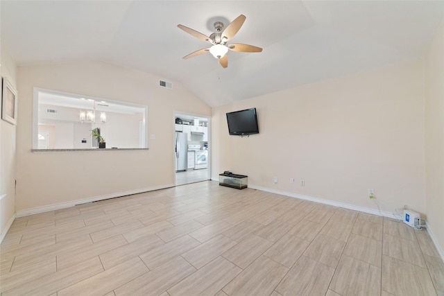 spare room with vaulted ceiling and ceiling fan with notable chandelier