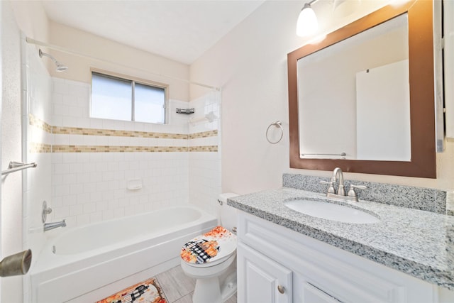 full bathroom featuring tiled shower / bath, tile patterned floors, vanity, and toilet