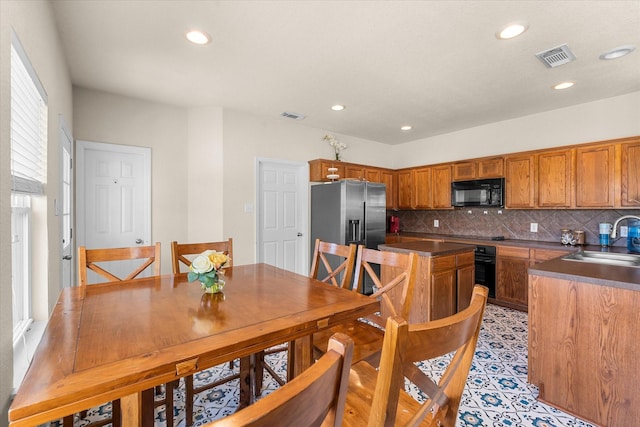 kitchen featuring black appliances, backsplash, and sink