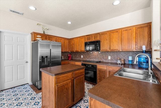 kitchen with light tile patterned flooring, backsplash, black appliances, sink, and a kitchen island