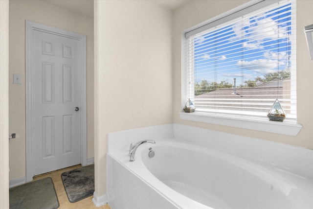 bathroom with tile patterned floors and a tub