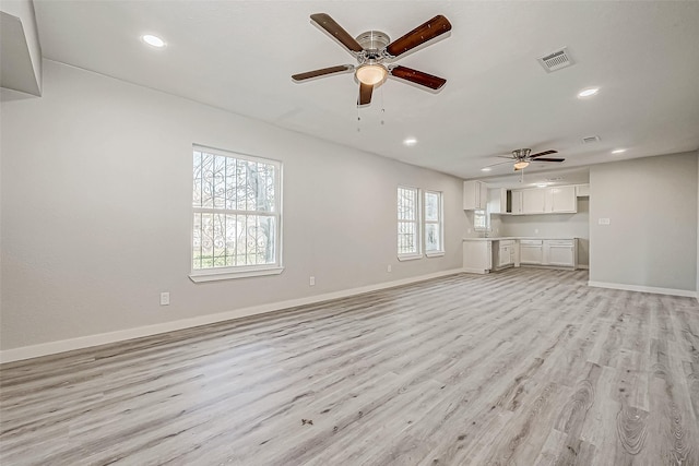 unfurnished living room featuring ceiling fan and light wood-type flooring