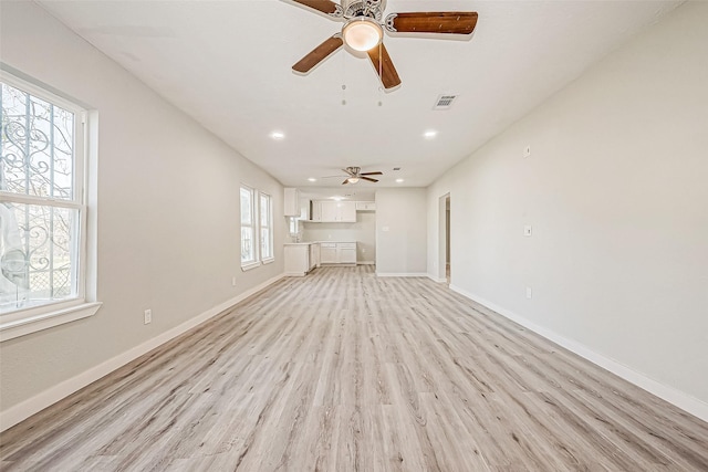 unfurnished living room with a wealth of natural light, light hardwood / wood-style flooring, and ceiling fan