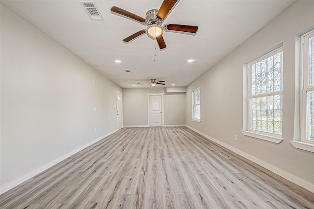 empty room with ceiling fan and light hardwood / wood-style flooring