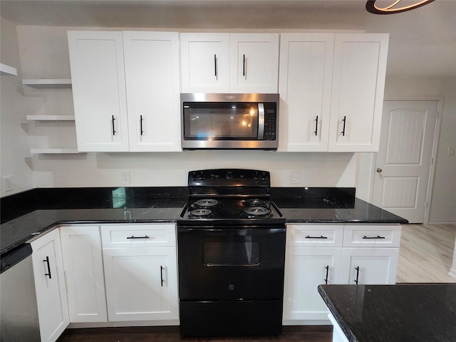 kitchen featuring white cabinets, stainless steel appliances, and dark stone counters