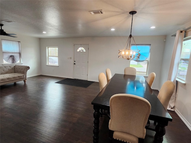 dining area with a notable chandelier, dark hardwood / wood-style flooring, and a textured ceiling