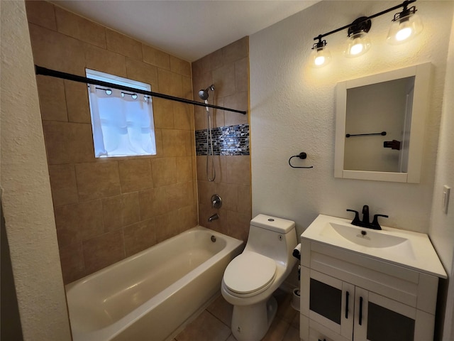 full bathroom with tile patterned flooring, vanity, tiled shower / bath combo, and toilet