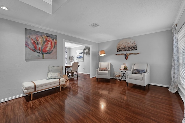 sitting room featuring a textured ceiling, dark hardwood / wood-style flooring, and crown molding