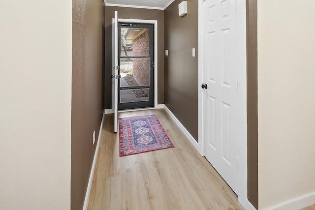 entryway with crown molding and light hardwood / wood-style flooring