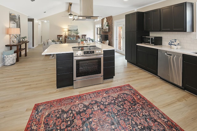 kitchen with lofted ceiling with beams, tasteful backsplash, light hardwood / wood-style floors, island exhaust hood, and stainless steel appliances