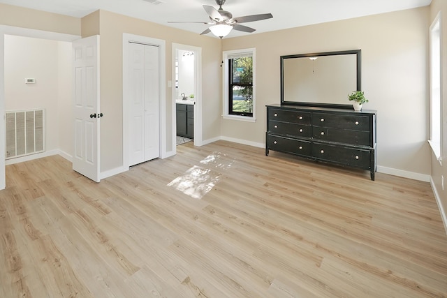 unfurnished bedroom featuring ensuite bath, ceiling fan, sink, and light hardwood / wood-style floors