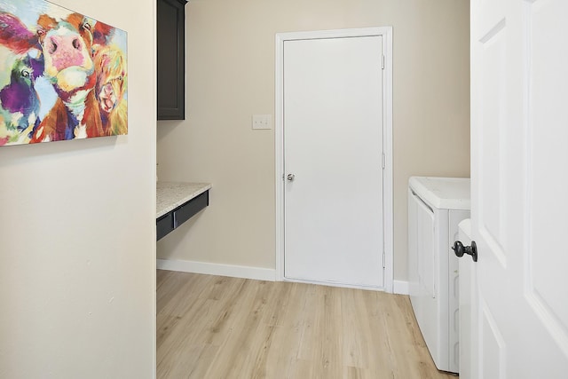 corridor with washer and dryer and light hardwood / wood-style floors