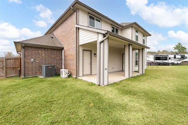 rear view of house with a lawn, ac unit, cooling unit, and a patio area