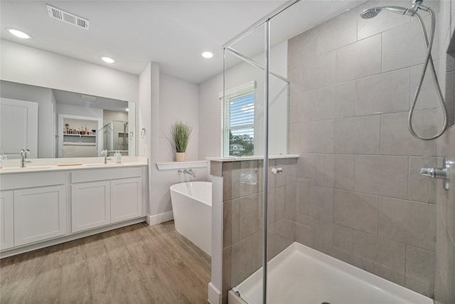 bathroom with vanity, hardwood / wood-style flooring, and independent shower and bath