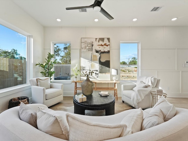 living room with ceiling fan, a healthy amount of sunlight, and light hardwood / wood-style flooring