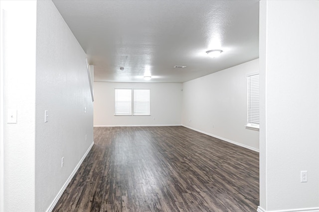 spare room with dark hardwood / wood-style flooring and a textured ceiling