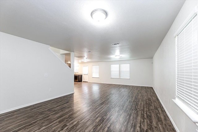 interior space featuring a textured ceiling and dark hardwood / wood-style floors