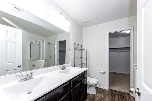 bathroom featuring wood-type flooring, vanity, toilet, and an enclosed shower