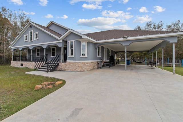 view of front of property featuring a carport, covered porch, and a front yard