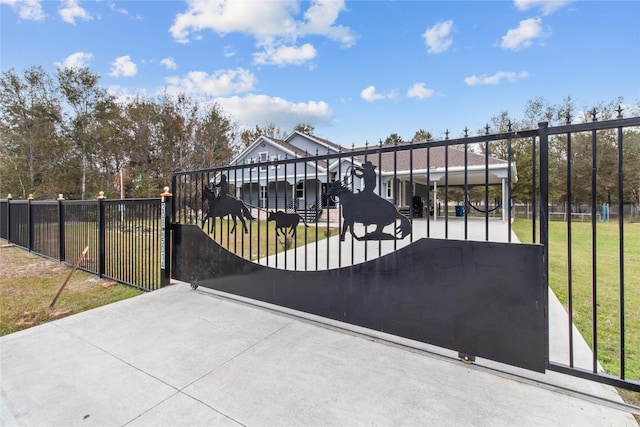 view of gate with a lawn