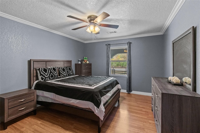 bedroom with ceiling fan, crown molding, light hardwood / wood-style floors, and a textured ceiling