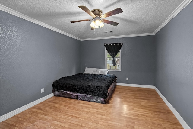 bedroom featuring a textured ceiling, light hardwood / wood-style floors, ceiling fan, and crown molding