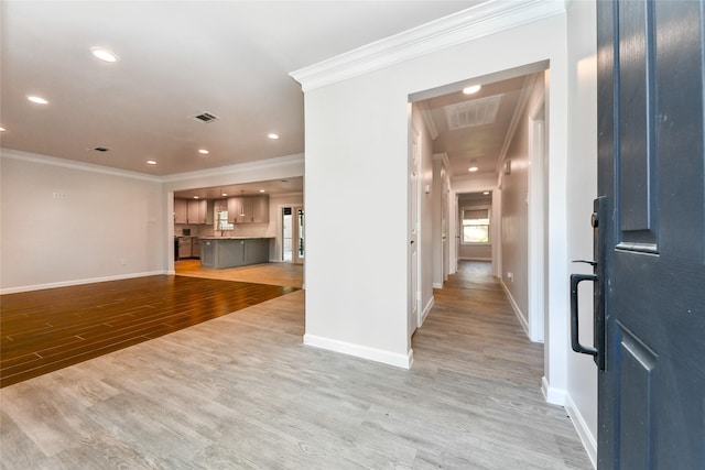 unfurnished living room featuring light wood-type flooring and ornamental molding