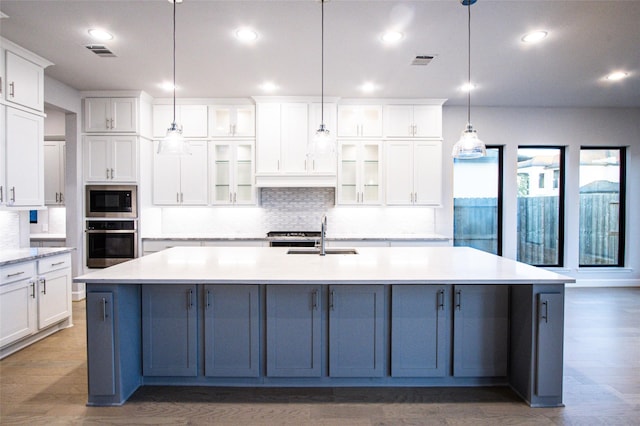 kitchen with oven, hanging light fixtures, and a spacious island