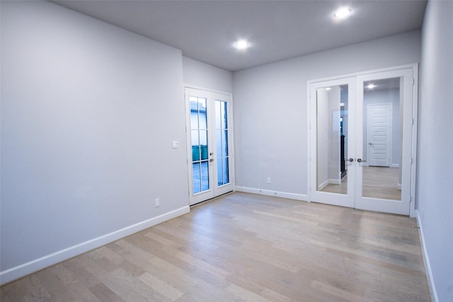 unfurnished room with french doors and light hardwood / wood-style flooring