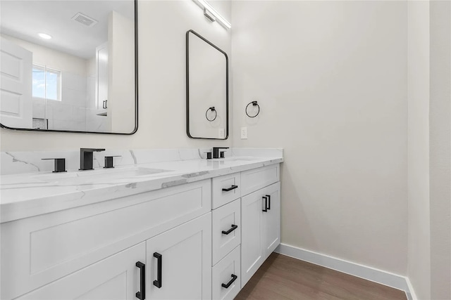 bathroom featuring hardwood / wood-style flooring, vanity, and a shower