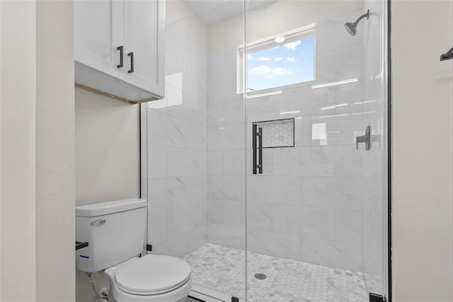 bathroom with a shower with door and toilet