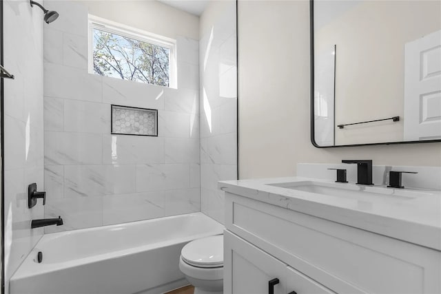 full bathroom featuring tiled shower / bath combo, toilet, and vanity