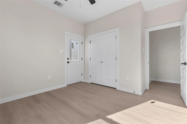 unfurnished bedroom with a closet, light hardwood / wood-style floors, and ceiling fan