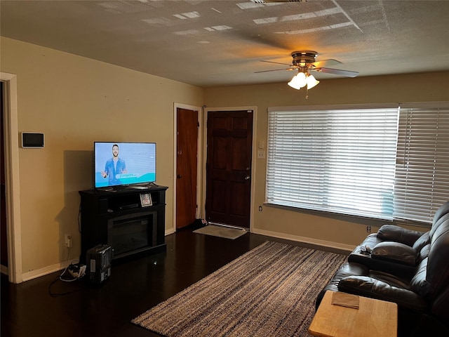 living room featuring ceiling fan and a textured ceiling