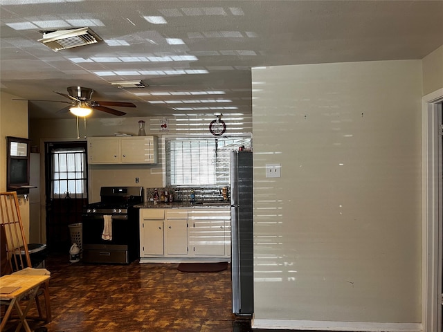 kitchen featuring white cabinetry, dark parquet flooring, ceiling fan, and appliances with stainless steel finishes