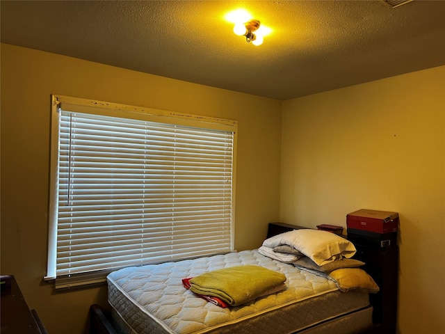 bedroom with multiple windows and a textured ceiling