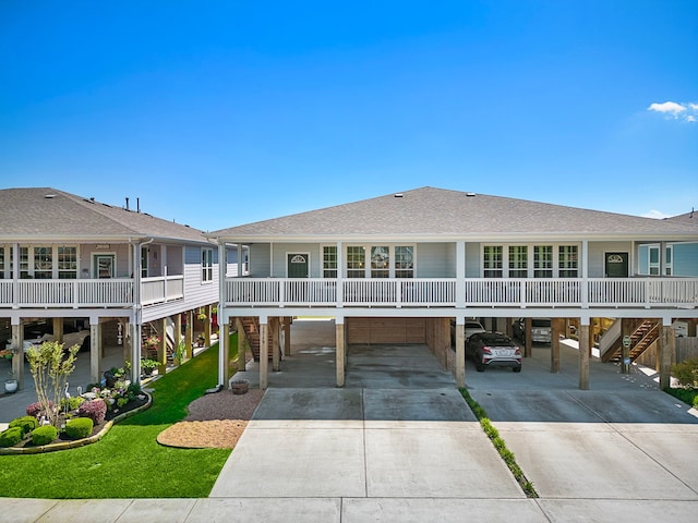 back of property featuring a carport and a lawn