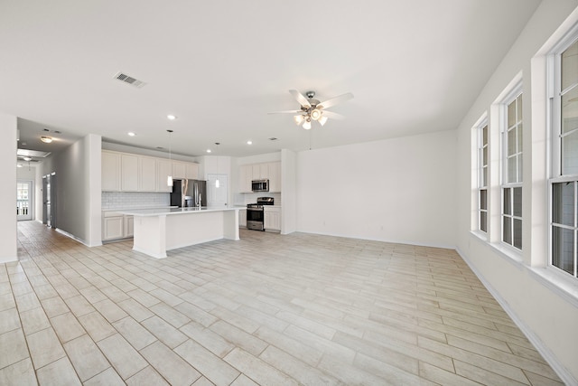 unfurnished living room with ceiling fan