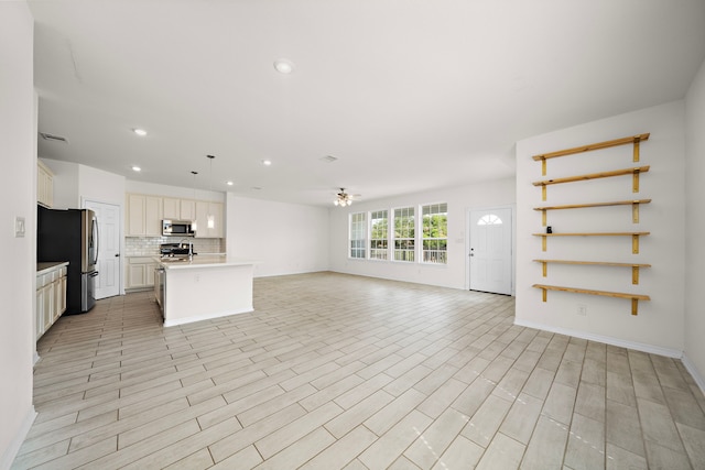 unfurnished living room featuring ceiling fan