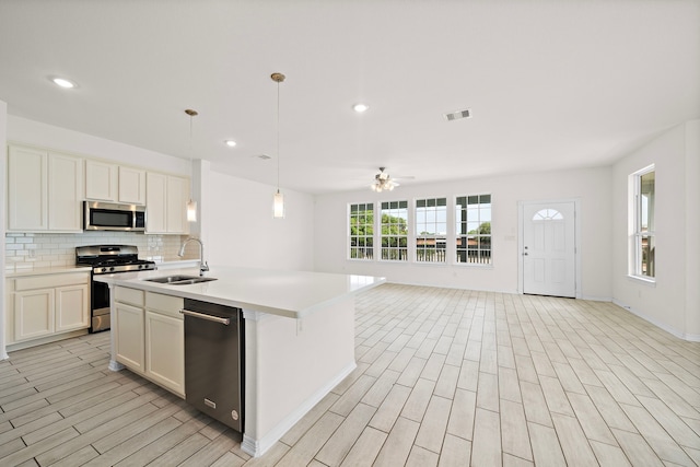 kitchen featuring appliances with stainless steel finishes, ceiling fan, sink, pendant lighting, and white cabinets