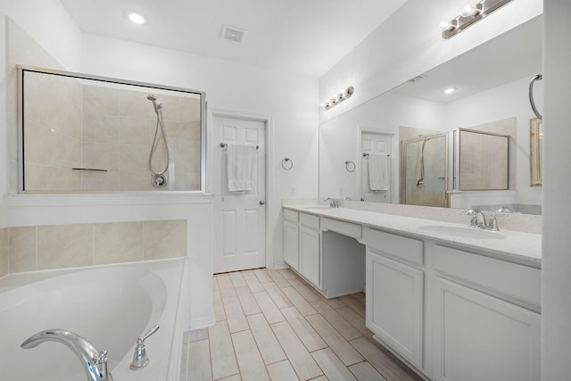 bathroom featuring shower with separate bathtub and vanity