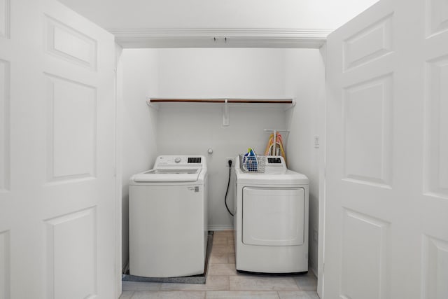 clothes washing area featuring washing machine and dryer and light tile patterned floors