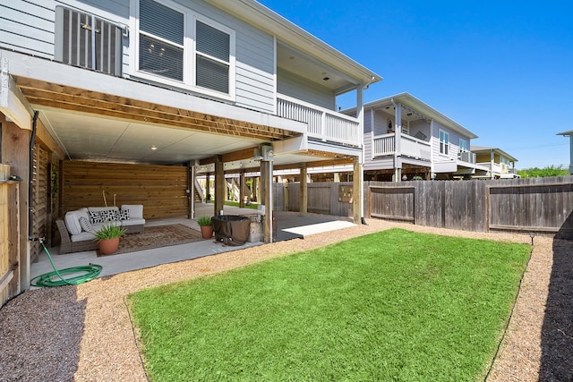 rear view of property featuring a lawn and a patio