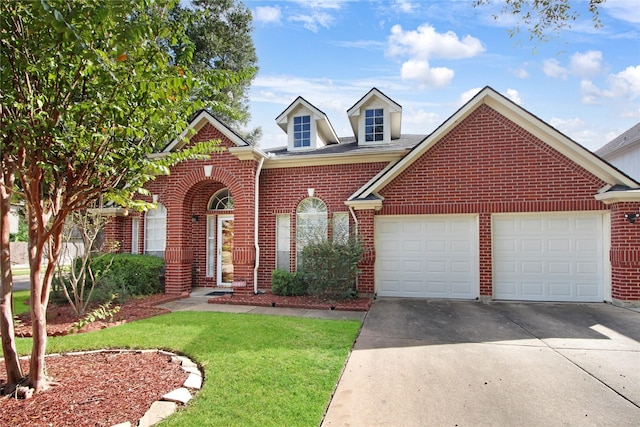 view of front of home with brick siding, driveway, a front yard, and a garage