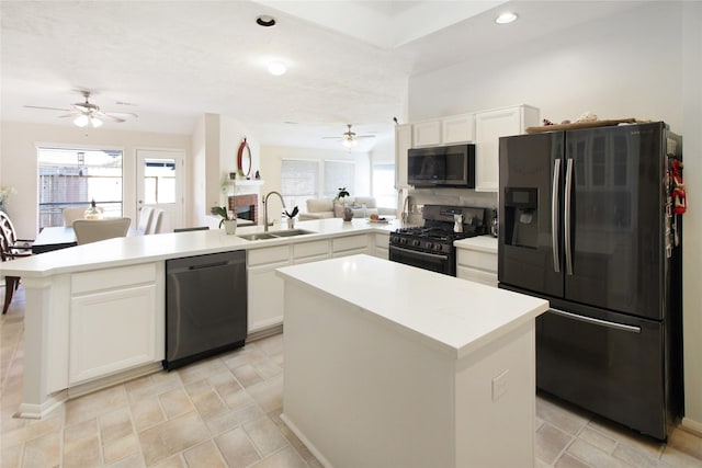 kitchen featuring range with gas cooktop, dishwasher, a peninsula, black refrigerator with ice dispenser, and a sink