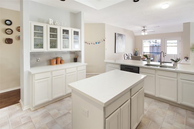 kitchen with white cabinets, dishwasher, sink, and a kitchen island