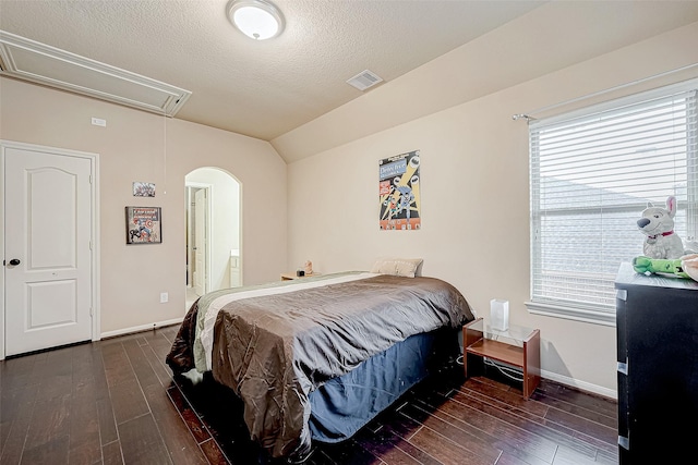 bedroom featuring a textured ceiling, lofted ceiling, and dark hardwood / wood-style floors