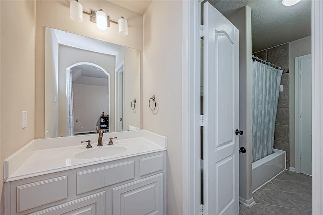 bathroom featuring tile patterned floors, vanity, shower / bath combo, and a textured ceiling