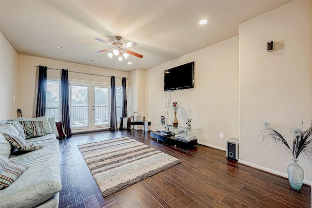 living room with ceiling fan, dark hardwood / wood-style flooring, and a textured ceiling